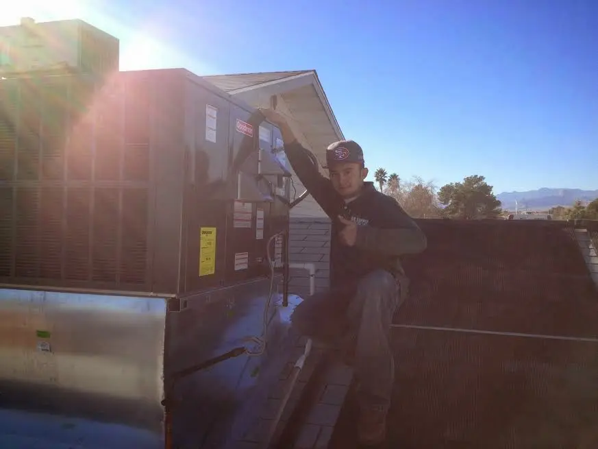 HVAC technician performing AC Tune-Up on a rooftop unit in Bartlesville